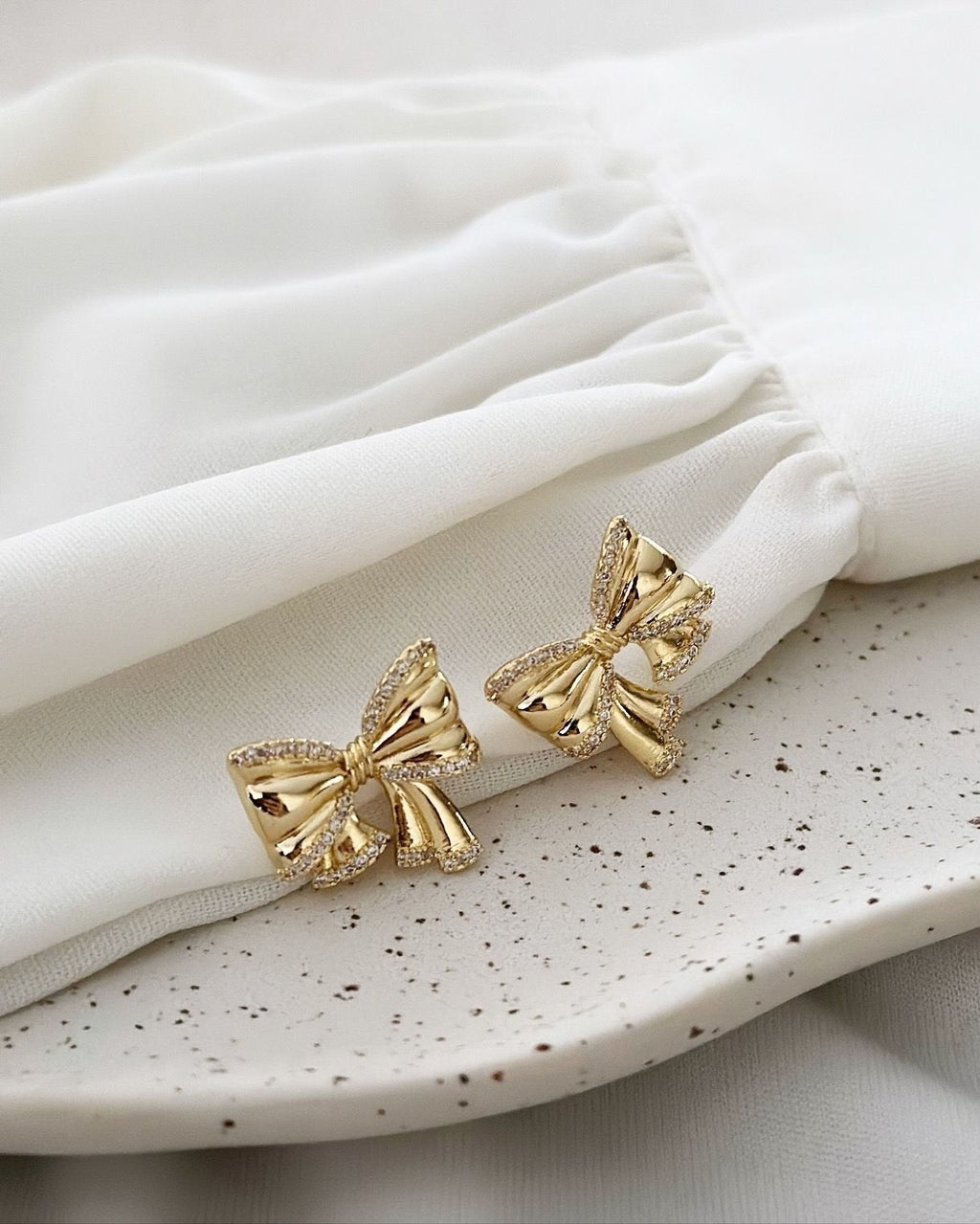 Brinco Folheado a ouro 18k Laço com borda cravejada com zirconias.